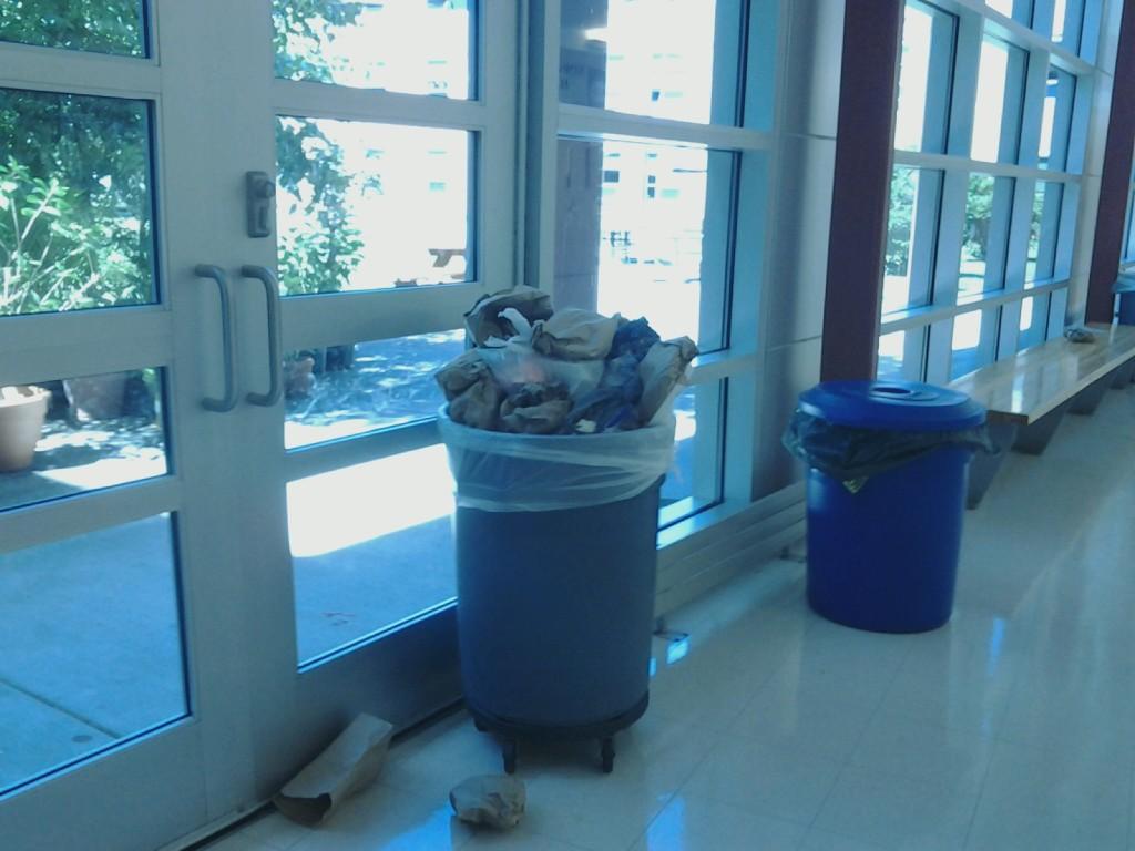 A trash can filled to the brim with lunch waste from Senior Row. 