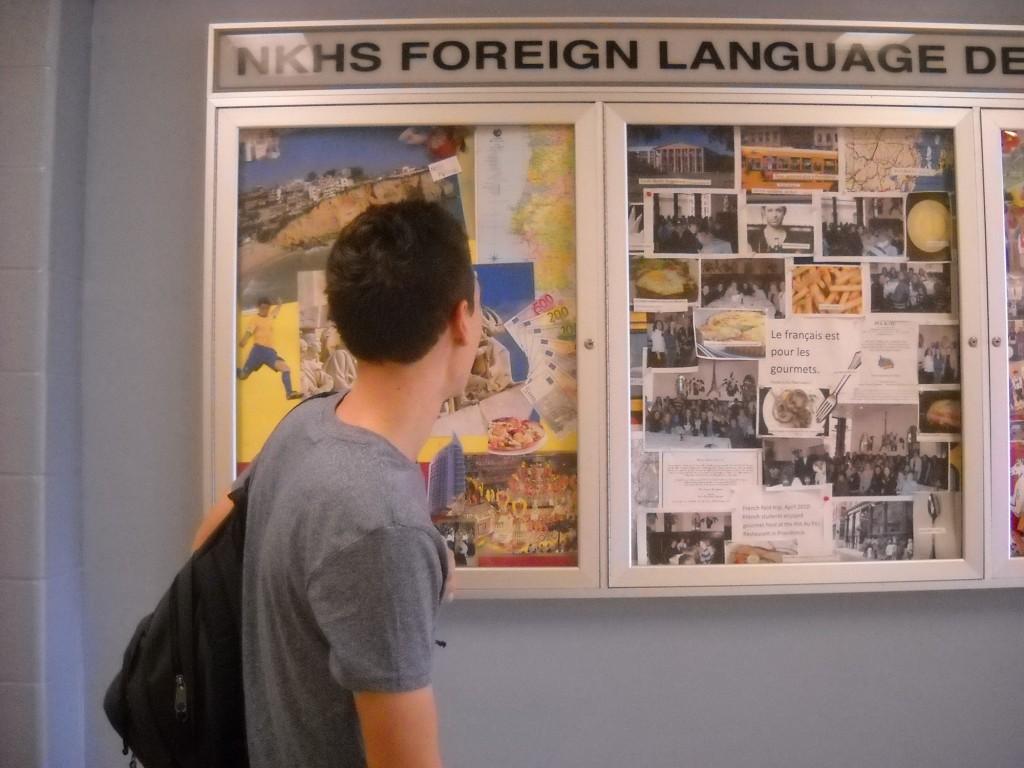 Senior Jasper Flour looks at photos from the exchange program posted in the hallway