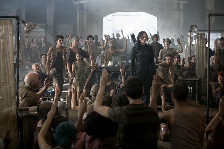 Hospital patients in District 8 raise their fingers in the mockingjay symbol to acknowledge their respect for Katniss and their committment to the rebellion. 