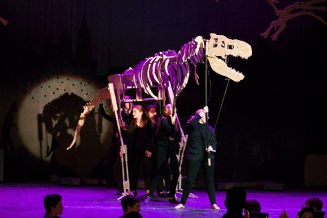 Students dressed in black operate the giant T-Rex puppet.  
