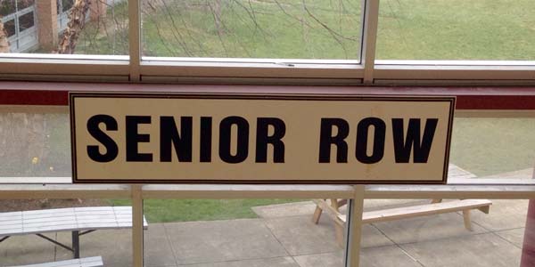 "Senior Row" sign that hangs over the benches. 