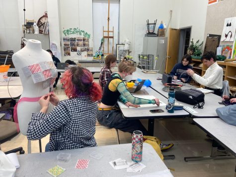 Students work on various pieces at Ms. Strains Art Club. A.J. Johnson (left) continues to create the newest Junk Couture clothing piece. Junk Couture is a project dedicated to creating fashion from recycled materials.